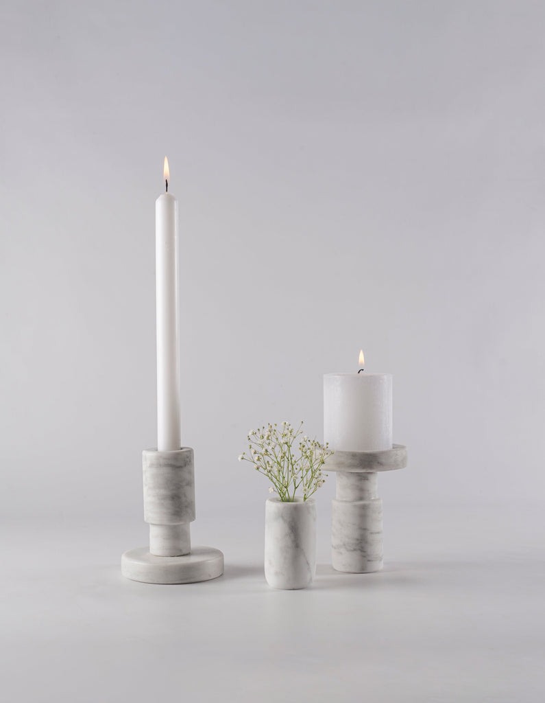 Portavelas decorativo de mármol como pieza central en la sala.
