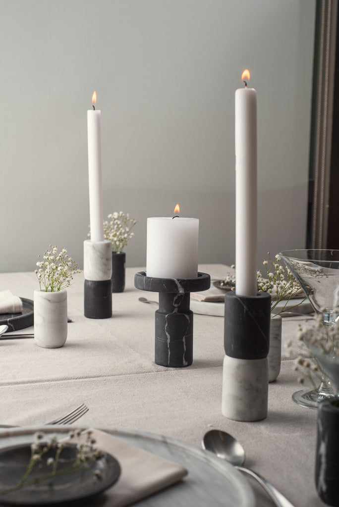 Velas encendidas en el Candle Holder Ying, destacando su diseño en mármol.
