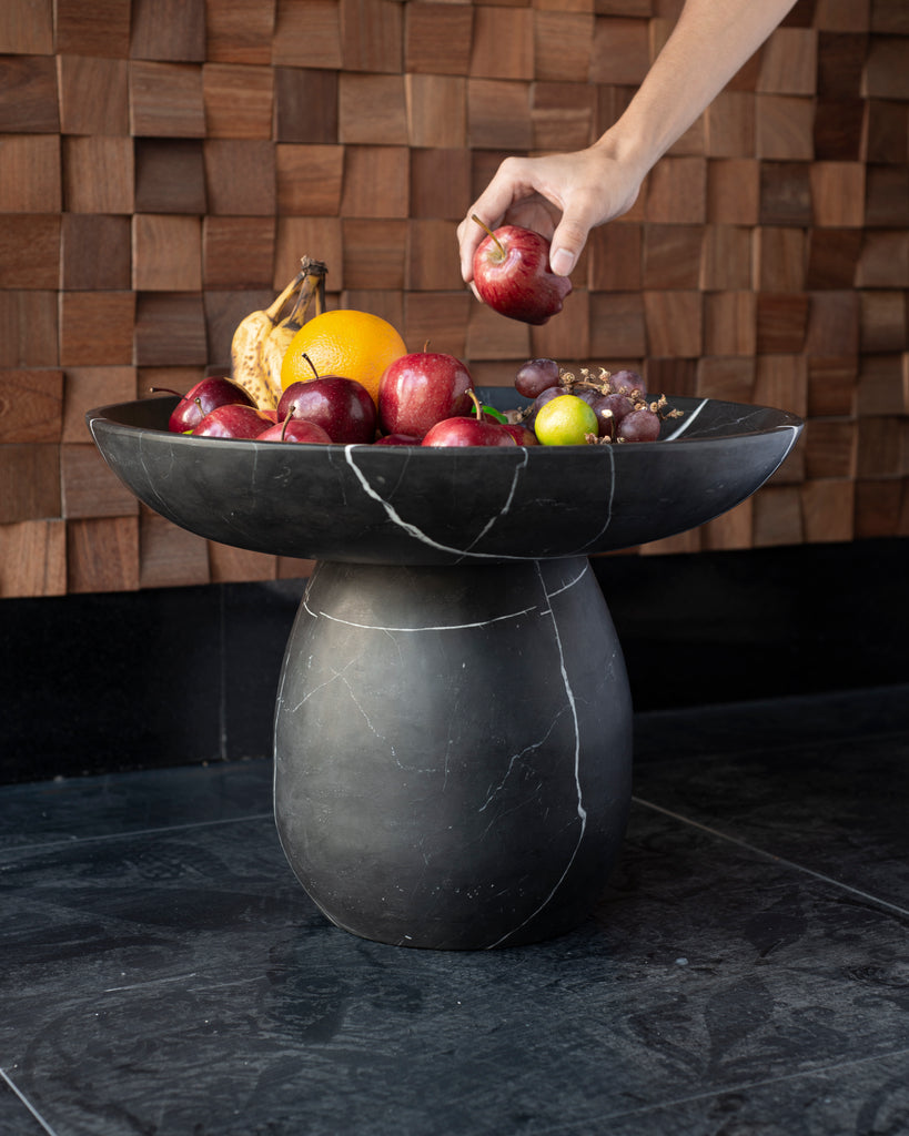Platón de mármol usado como pieza escultórica en una sala de estar.
