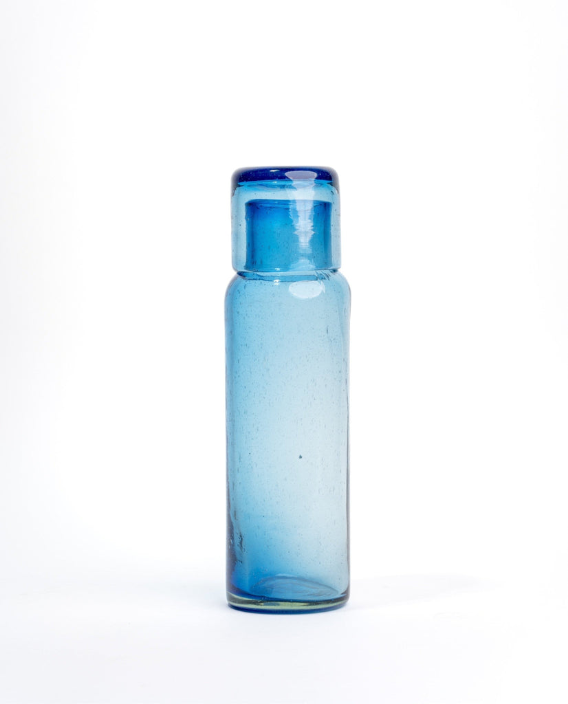 Elegante jarra con vaso, diseño único para decoración de interiores.
